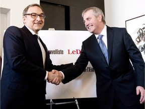 Martin Cauchon, owner of the Groupe Capitales Média, and Claude Gagnon, president and director general, shake hands after they announced the purchase of six newspapers that were owned by Gesca, Wednesday, March 18, 2015 in Quebec City.