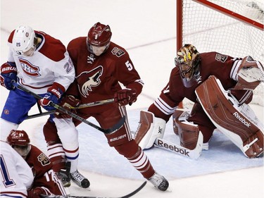 Arizona Coyotes' Mike Smith, right, gives up a goal to Montreal Canadiens' Lars Eller, of Denmark, as Coyotes' Connor Murphy (5) and Canadiens' Jacob De La Rose (25), of Sweden, battle for position in front of the goal during the second period of an NHL hockey game Saturday, March 7, 2015, in Glendale, Ariz.