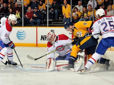 Greg Pateryn and Jacob De La Rose of the Montreal Canadiens defend Filip Forsberg of the Nashville Predators  in front of Canadiens goalie Carey Price during the first period at Bridgestone Arena on March 24, 2015 in Nashville, Tenn.