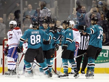 Joe Pavelski (#8) of the San Jose Sharks is congratulated by Brent Burns (#88) and Joe Thornton (#19) after he scored a power-play goal in the first period against the Montreal Canadiens at SAP Center on March 2, 2015 in San Jose, California.