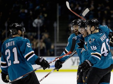 Matt Irwin (#52) of the San Jose Sharks is congratulated by Ben Smith (#21), Brent Burns (#88), and Tomas Hertl (#48) after scoring a goal against the Montreal Canadiens in the second period at SAP Center on March 2, 2015 in San Jose, California.