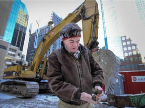 Freelance photographer and local historian Robert Galbraith breaks apart a clump of dirt on the construction site on Blvd. de Maisonneuve in Montreal Monday February 16, 2015 that he had shut down until it could be determined if it was the location of Hochelaga.