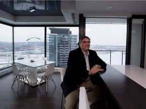 Alan Kezber sits at the kitchen island in his condo in Nuns' Island.