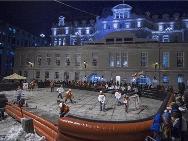 A road hockey game is played in the parking area behind Montreal City hall in Old Montreal during Nuit Blanche on Saturday, Feb. 28, 2015.