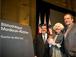 Montreal Mayor Denis Coderre, left, Florence Richler, wife of Mordecai Richler, and son Noah Richler unveil the new sign for the Mordecai-Richler Library during an event at city hall, where Mordecai Richler was also named as a citizen of honour on Thursday.