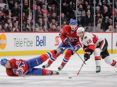 Centre Lars Eller, left, falls as he and teammate Jacob De La Rose, centre, fight for the puck against Ottawa Senators left wing Mike Hoffman during the second period at the Bell Centre on Thursday, March 12, 2015.