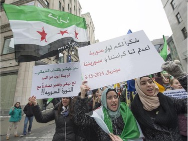 Demonstrators in Montreal march on the fourth anniversary of the start of uprising against the Syrian government and are calling for democracy for the people of Syria on Saturday, March 15, 2014. The sign in the foreground right, says "Thank you Syrian revolutionists for our honour."