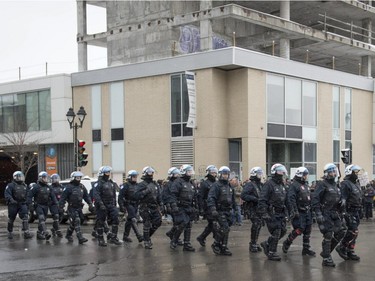 Police march along Ontario at the corner of Berri St. prior to a protest Opposed to Police Brutality in Montreal, on Sunday, March 15, 2015.