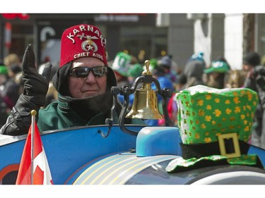 A member of the Shriners drives a miniature train as he participates in the annual St. Patrick's parade along Ste-Catherine St. in Montreal on Sunday March 22, 2015.