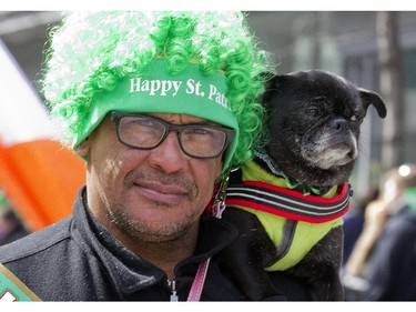 A parade participant walks with a dog during the annual St. Patrick's parade along Ste- Catherine St. in Montreal on Sunday March 22, 2015.