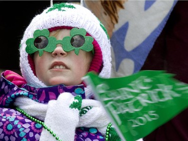 Six-year-old Bethany Vienneau watches a passing float during the annual St. Patrick's parade along Ste- Catherine St. in Montreal on Sunday March 22, 2015.