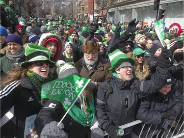 Spectators applaud a passing float during the annual St. Patrick's parade along Ste- Catherine St. in Montreal on Sunday March 22, 2015.
