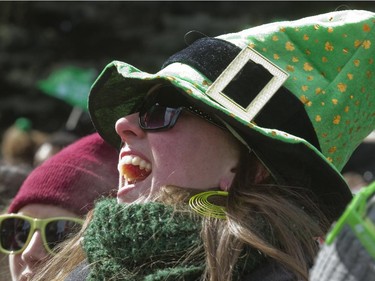 Spectator Sandra Buchanan applauds a passing float during the annual St. Patrick's parade along Ste- Catherine St. in Montreal on Sunday March 22, 2015.