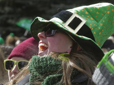 Spectators Sandra Buchanan applauds a passing float during the annual St. Patrick's parade along Ste- Catherine St. in Montreal on Sunday March 22, 2015.