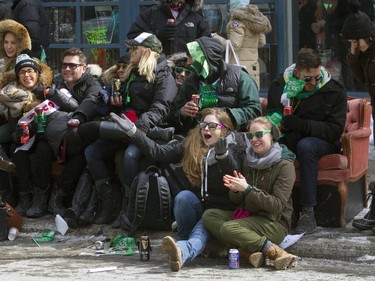 Spectators sit on a couch on the sidewalk to watch the annual St. Patrick's parade on Ste- Catherine St. in Montreal on Sunday March 22, 2015.