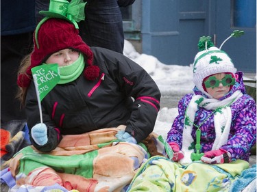 MARCH 22, 2015 -- Tatum Leggo, 11, left, and Bethany Vienneau, 6, watch the annual St Patrick's parade along Ste- Catherine St. in Montreal on Sunday March 22, 2015.