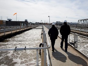 Michel Germain, assistant intendant of operations, left, and Patrice Langevin, assistant intendant of engineering and process, walk between the grit removal tanks at the Montreal sewage treatment facility in Montreal on Monday March 23, 2015.