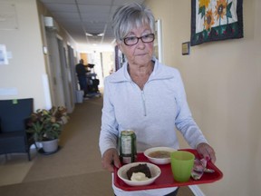Heather Lefebvre, a volunteer at the West Island Palliative Care Residence in Kirkland, takes lunch to a patient, on Tuesday, March 24, 2015.
