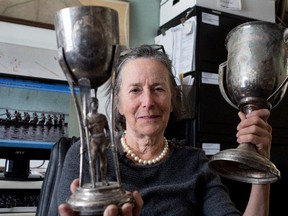 Sonni Malo, vice-president of St-Lambert's Mouillepied Historical Society, with two old trophies found in the garbage and given to the society.
