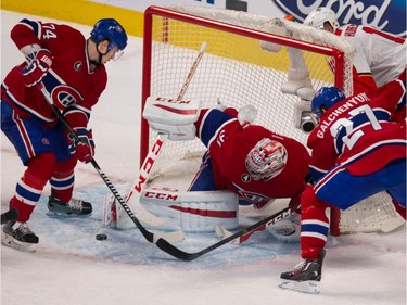 Canadiens defenceman Alexei Emelin, left, tries to help goalie Carey Price cover up as Alex Galchenyuk, right, looks on during NHL action at the Bell Centre in Montreal on Saturday March 28, 2015.