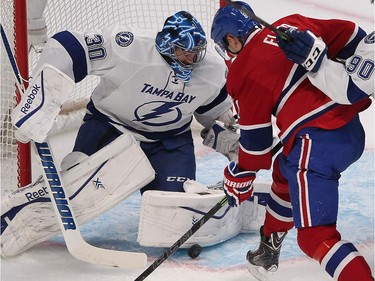 Brian Flynn of the Canadiens gets in close with puck on Tampa Bay Lightning goalie Ben Bishop during first period- NHL action in Montreal on Monday, March 30, 2015.