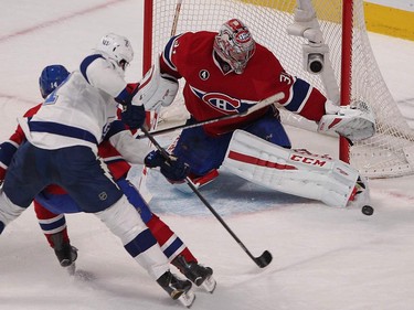 Montreal Canadiens goalie Carey Price stops shot by Tampa Bay Lightning's Brian Boyle, centre, being blocked by Tomas Plekanec during first-period action in Montreal on Monday, March 30, 2015.