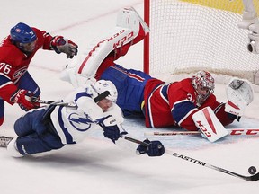 Montreal Canadiens goalie Carey Price keeps eye on the puck on shot by Tampa Bay Lightning's Alex Killorn, who is brought down by P.K. Subban during first-period action in Montreal on Monday, March 30, 2015.