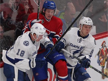 Montreal Canadiens' Jeff Petry is forced into the boards by Tampa Bay Lightning's Ondrej Palat, left, and Vladislav Namestnikov during second-period action in Montreal on Monday, March 30, 2015.