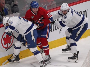 Montreal Canadiens right wing P.A. Parenteau gets tangled up with  J.T. Brown, left, and Mark Barberio of the Tampa Bay Lightning during first- period action in Montreal on Monday March 30, 2015.