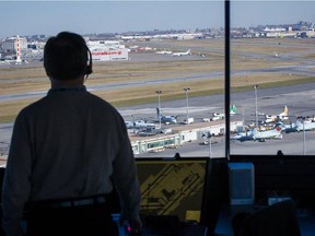 An air traffic controller looks over the airport runways in the control tower at the Pierre Elliott Trudeau International Airport in Montreal on Wednesday, November 20, 2013.