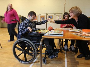 Natalie Chapman, executive director of WIAIH (West Island Association for the Intellectually Handicapped) has some fun with Mohammad Darwiche and Tanya James at an Amuse Action session Monday, October 3, 2011 in the Pointe Claire area of Montreal. Amuse Action is a service that provides afternoon care for people over 12-years-old who have an intellectual handicap or autism. Behind is Tracy Wrench, manager of the WIAIH recreation department.