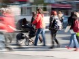 A woman tries to manoeuvre a baby stroller through the busy lunch time crowd on Ste. Catherine St in Montreal in 2011.