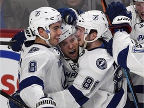 Tampa Bay Lightning right wing Nikita Kucherov, right, celebrates with teammates Mark Barberio, left, and Tyler Johnson, centre after scoring the winning goal against the Montreal Canadiens during overtime action at the Bell Centre Tuesday, March 10, 2015.