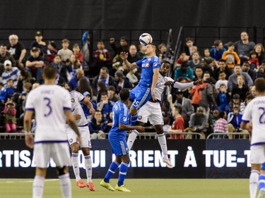 Donny Toia #25 of Montreal Impact gives a header with Bryan Rochez #35 of Orlando City SC jumping behind him during the MLS game against the Orlando City SC at the Olympic Stadium on March 28, 2015, in Montreal, between Orlando City SC and the Montreal Impact ended in a 2-2 draw.