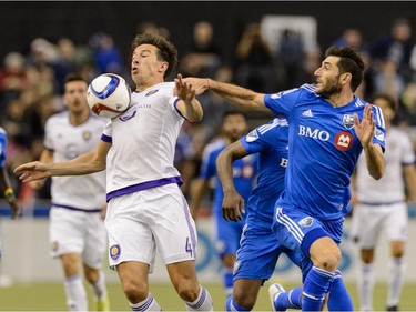 Sean St. Ledger #4 of the Orlando City SC plays the ball with his chest as Ignacio Piatti #10 of Montreal Impact tries to challenge him during the MLS game at the Olympic Stadium on March 28, 2015, in Montreal, Quebec, Canada.  The game between Orlando City SC and the Montreal Impact ended in a 2-2 draw.