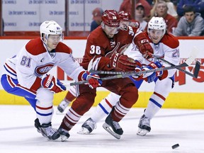 Arizona Coyotes centre Mark Arcobello (36) gets tripped up by Montreal Canadiens center Lars Eller (81), left, as they fight for the puck during the second period of an NHL hockey game Saturday, March 7, 2015, in Glendale, Ariz.
