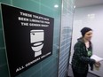 A protester walks out of a men's washroom at Simon Fraser University as others occupy the inside during a demonstration in Burnaby, B.C., on Wednesday, Feb. 18, 2015. A group of transgender, gender-variant and other students occupied washrooms on campus in an effort to bring awareness to what protesters say is a lack of gender-inclusive washrooms.