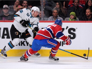 Matt Irwin #52 of the San Jose Sharks passes the puck in front of Brendan Gallagher #11 of the Montreal Canadiens during the NHL game at the Bell Centre on March 21, 2015, in Montreal.