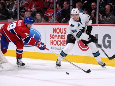 Melker Karlsson #68 of the San Jose Sharks passes the puck in front of Andrei Markov #79 of the Montreal Canadiens during the NHL game at the Bell Centre on March 21, 2015, in Montreal.