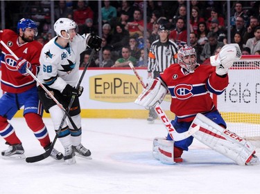 Carey Price  of the Montreal Canadiens makes a glove save on the puck in front of teammates Andrei Markov #79 and Melker Karlsson #68 of the San Jose Sharks during the NHL game at the Bell Centre on March 21, 2015, in Montrea.