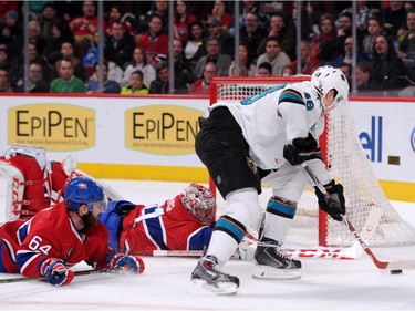 Carey Price  of the Montreal Canadiens stretches out to stop the puck on an attempt by Tomas Hertl #48 of the San Jose Sharks during the NHL game at the Bell Centre on March 21, 2015 in Montreal.