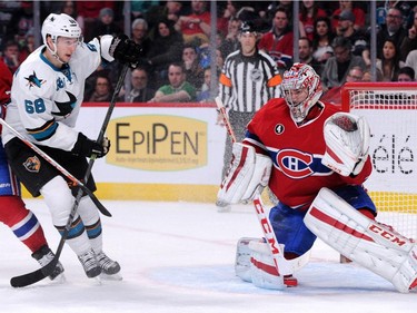Carey Price of the Montreal Canadiens makes a glove save on the puck in front of Melker Karlsson #68 of the San Jose Sharks during the NHL game at the Bell Centre on March 21, 201, in Montreal.