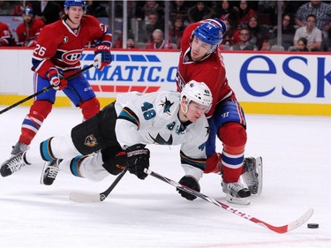 Alexei Emelin #74 of the Montreal Canadiens takes down Tomas Hertl #48 of the San Jose Sharks during the NHL game at the Bell Centre on March 21, 2015 in Montreal, Quebec, Canada.  The Canadiens defeated the Sharks 2-0.