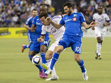 Orlando City SC's Sean St. Ledger gets caught in between Montreal Impact's Ignacio Piatti, right, and Nigel Reo-Coker during second half MLS action on Saturday, March 28, 2015, in Montreal.