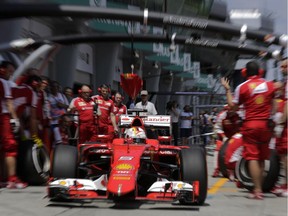 Ferrari driver Sebastian Vettel of Germany steers his car out of the pit after a tire change during the second practice session for the Malaysian Grand Prix on March 27, 2015.