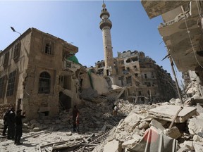 Syrians check the rubble following air strikes by government forces helicopters on the eastern Shaar neighbourhood of the northern Syrian city of Aleppo on March 27, 2015.