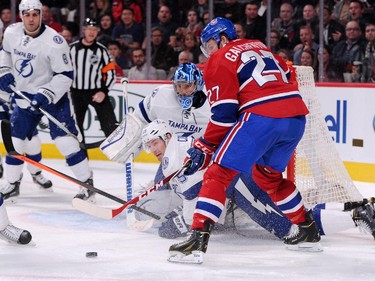 Alex Galchenyuk of the Montreal Canadiens watches the rebounding puck in front of Ben Bishop and Braydon Coburn of the Tampa Bay Lightning at the Bell Centre on Tuesday, March 10, 2015.