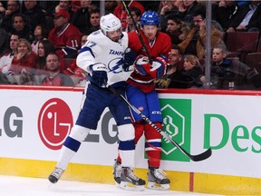 Alex Killorn of the Tampa Bay Lightning checks the Canadiens' Jeff Petry into the boards during game at the Bell Centre on March 10, 2015. The Lightning won 1-0 in overtime.