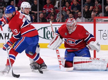 Carey Price looks for the rebounding puck in front of Tyler Johnson and teammate Andrei Markov at the Bell Centre on Tuesday, March 10, 2015.