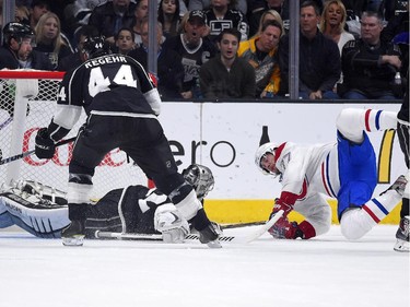 Montreal Canadiens defenceman Tom Gilbert, right, falls as he scores on Los Angeles Kings goalie Jonathan Quick, lower left, as defenceman Robyn Regehr watches during the second period of an NHL hockey game, Thursday, March 5, 2015, in Los Angeles.